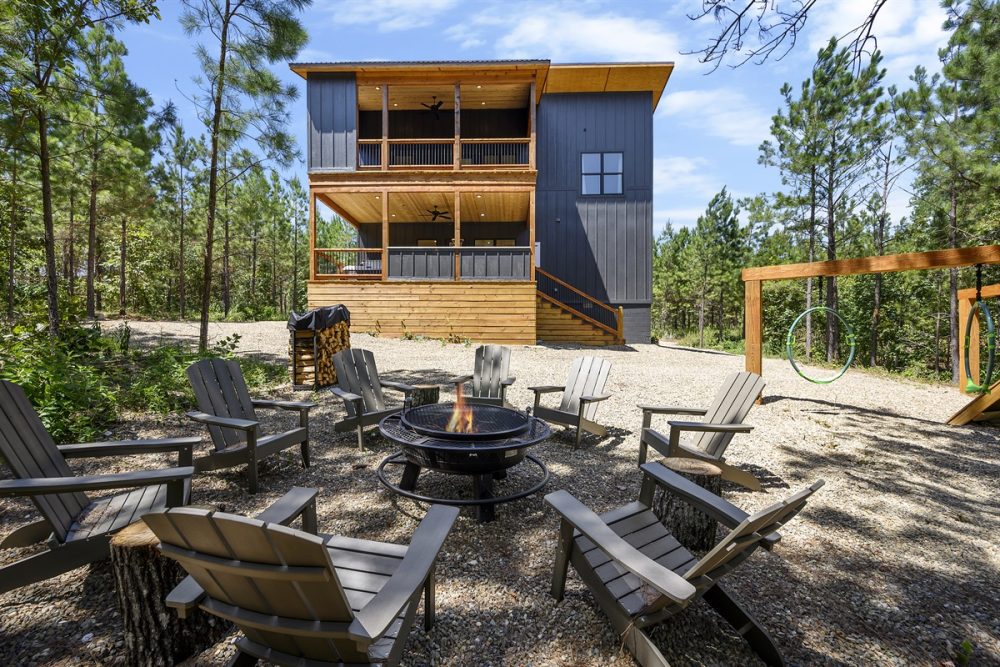 Modern cabin rental in a wooded setting, featuring a spacious deck, fire pit, and outdoor