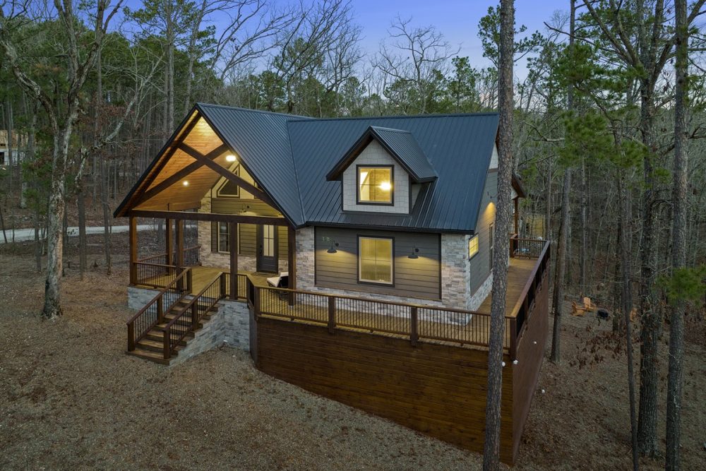 Cozy cabin in a wooded setting, featuring a modern design with a dark metal roof