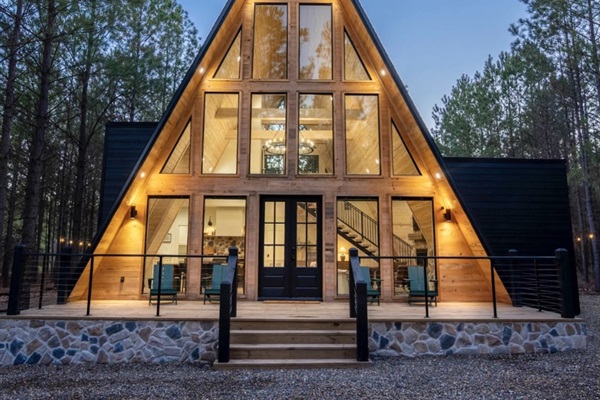 A-Frame luxury cabin with modern amenities, featuring large windows, a welcoming entrance, and outdoor seating