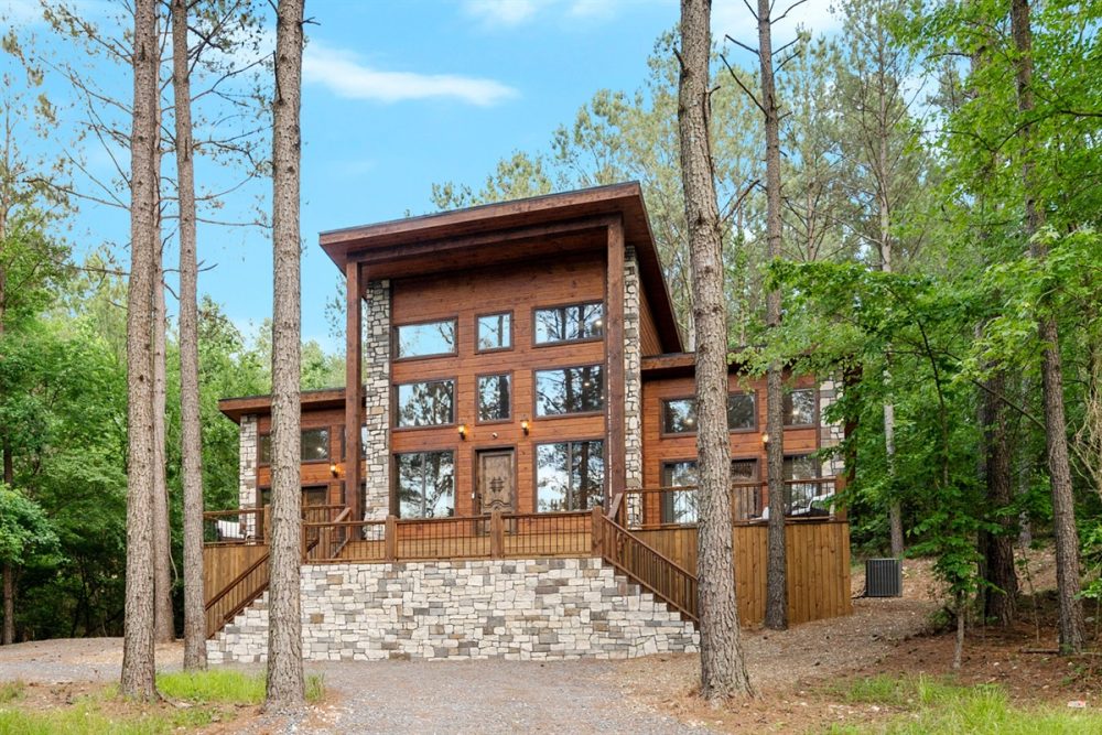Luxury cabin exterior in Broken Bow, Oklahoma, showcasing a modern design with large windows